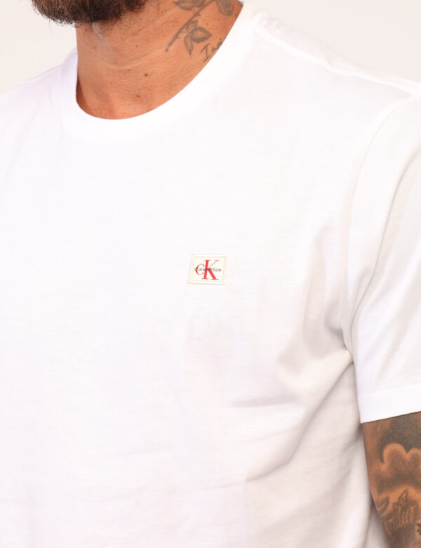 T-shirt Calvin Klein Bianco - T-shirt classica in total bianco con patch logo brand rosso. La vestibilità è morbida e regola