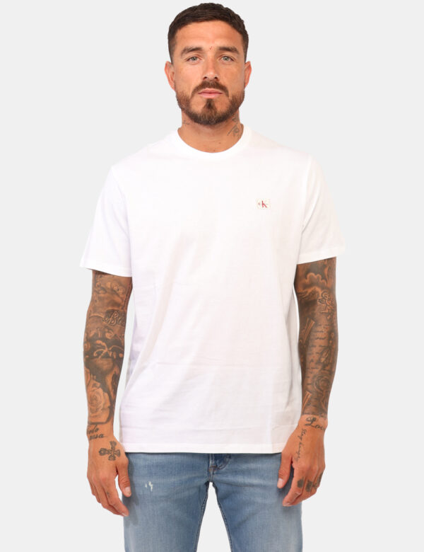 T-shirt Calvin Klein Bianco - T-shirt classica in total bianco con patch logo brand rosso. La vestibilità è morbida e regola