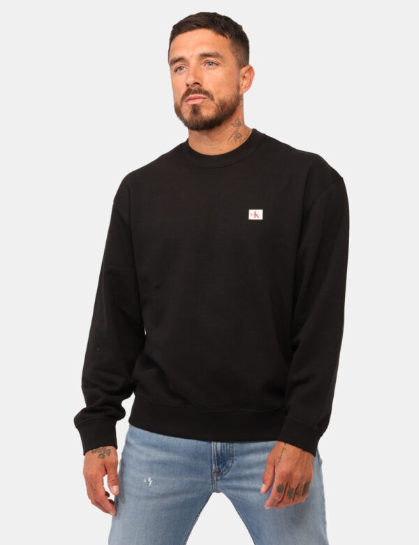 Felpa Calvin Klein Nero - Felpa classica, garzata, in total nero con patch logo brand. La vestibilità è morbida e regolare.