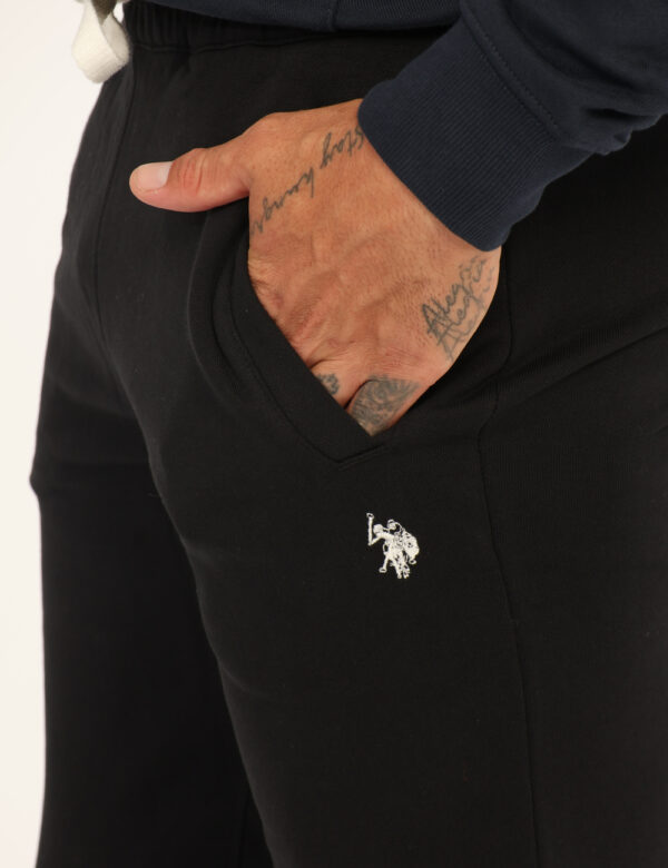 Pantaloni U.S. Polo Assn. Nero - Pantaloni tuta in cotone e total nero, con logo brand ricamato bianco e tasche a taglio tra