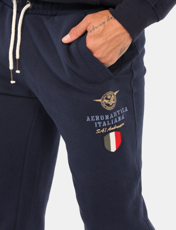 Pantaloni Aeronautica Italiana Blu - Pantalone tuta in total blu navy, con patch logo brand e tasche a taglio trasversale. L