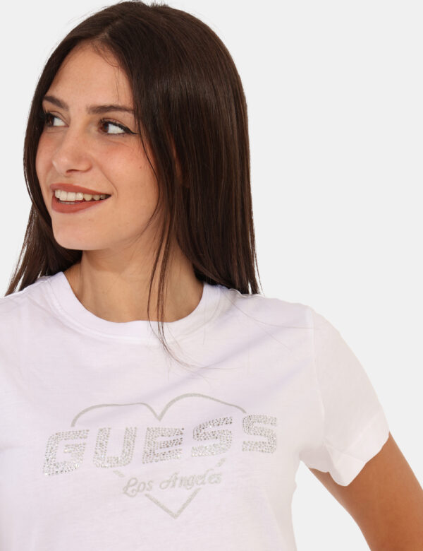 T-shirt Guess Bianco - T-shirt classica su base bianco con stampa logo brand in glitter argentati. La vestibilità è morbida