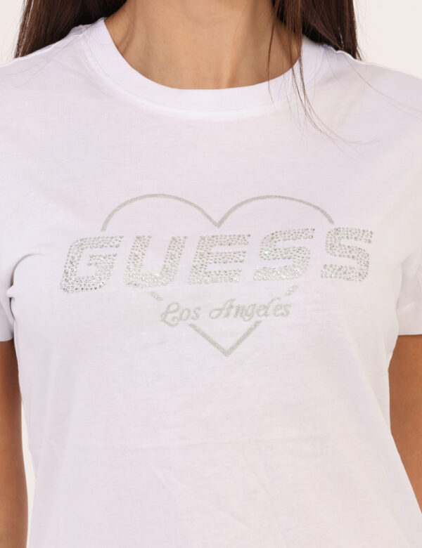 T-shirt Guess Bianco - T-shirt classica su base bianco con stampa logo brand in glitter argentati. La vestibilità è morbida
