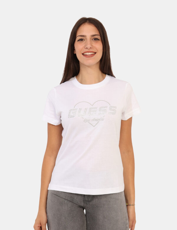 T-shirt Guess Bianco - T-shirt classica su base bianco con stampa logo brand in glitter argentati. La vestibilità è morbida