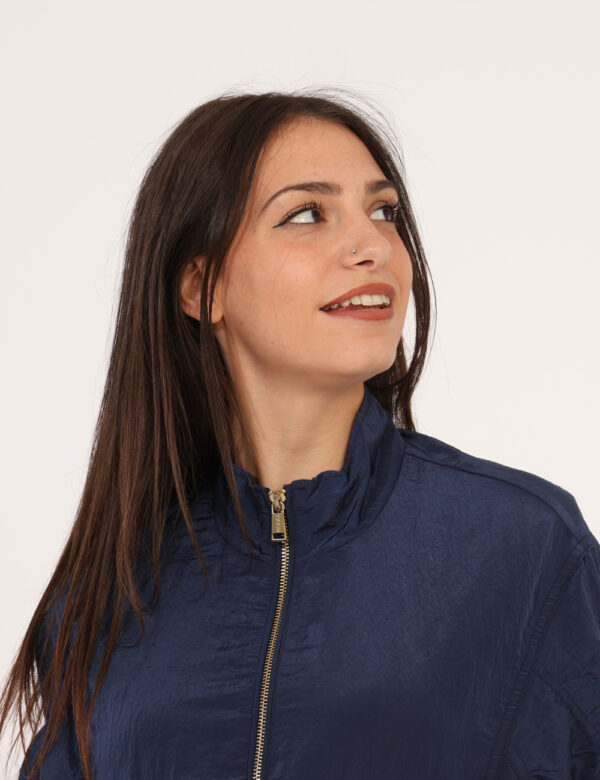 Giacca Guess Blu - Giacca in crepe in total blu, con tasche a taglio trasversale e chiusura a zip, più nastro in girovita. L