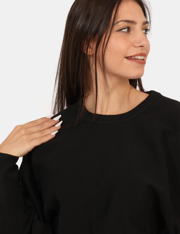 Maglione Guess Nero - Maglione corto, in total nero con girocollo classico e polsini. La vestibilità è morbida e regolare. L