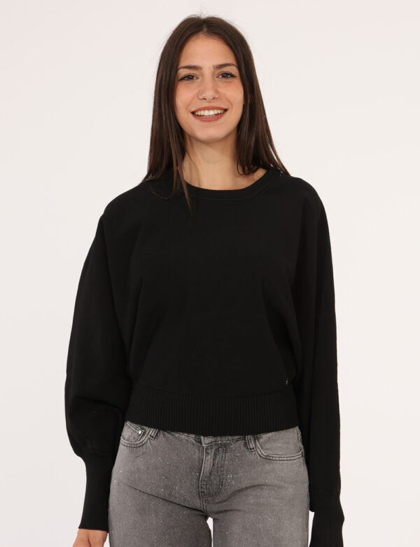 Maglione Guess Nero - Maglione corto, in total nero con girocollo classico e polsini. La vestibilità è morbida e regolare. L