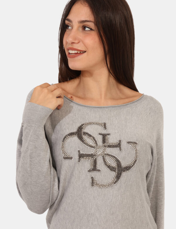 Maglione Guess Grigio - Maglione in total grigio chiaro con logo brand in glitter e perline coordinate. La vestibilità è mor