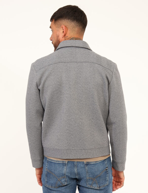 Cappotto Prj22. Grigio - Cappotto corto su fantasia rigata grigio/blu con tasche a taglio trasversale e chiusura a bottone.