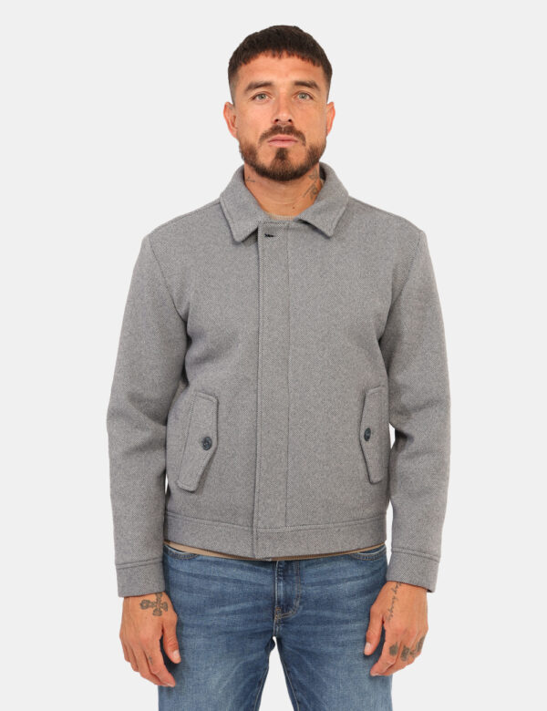 Cappotto Prj22. Grigio - Cappotto corto su fantasia rigata grigio/blu con tasche a taglio trasversale e chiusura a bottone.
