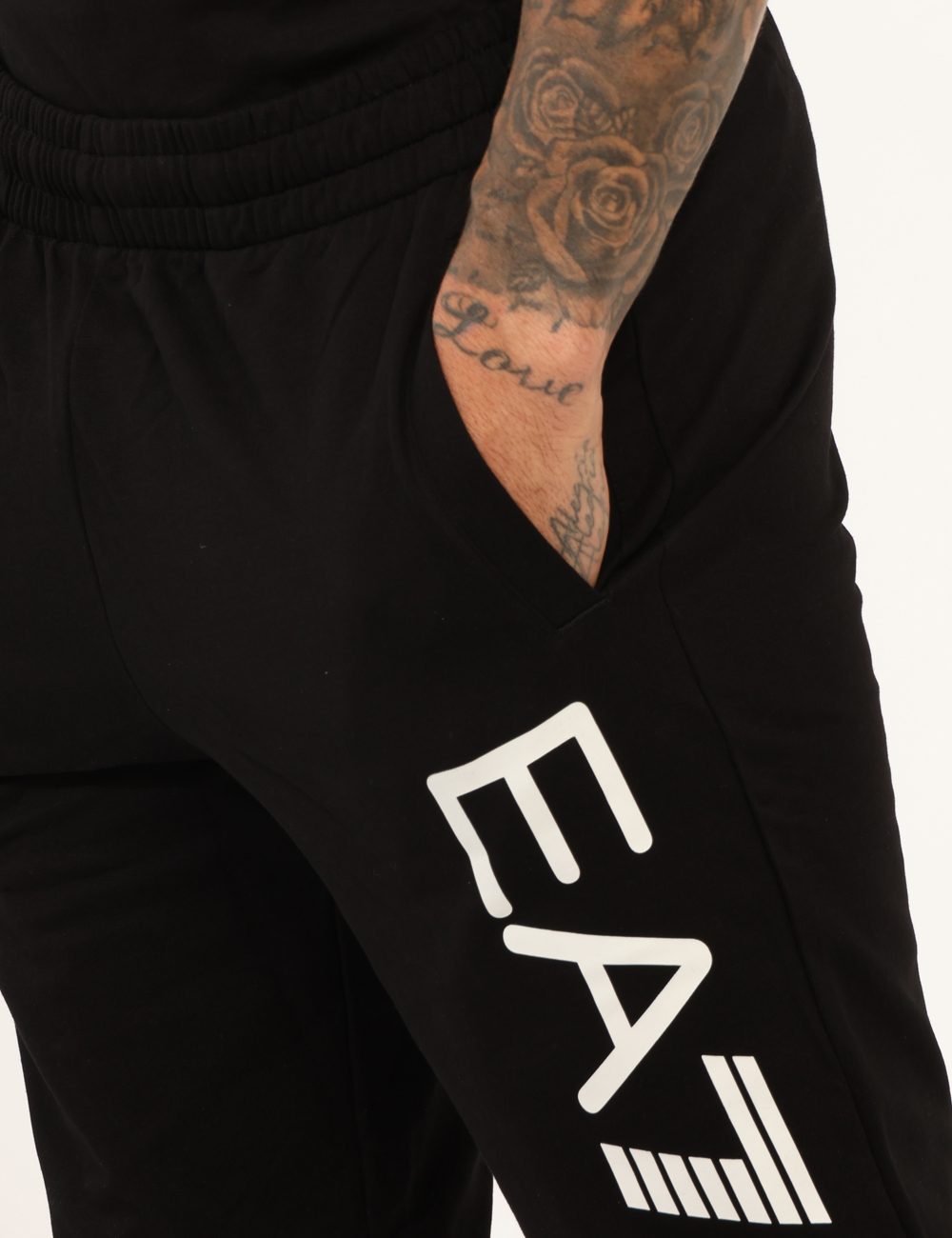 7M000571-AF13512-OA_BLACK-WHITE_AI25_3 Pantaloni EA7 Nero - Pantaloni in total nero, con stampa logo brand bianca, tasche a taglio trasversale sul fronte e tasca a