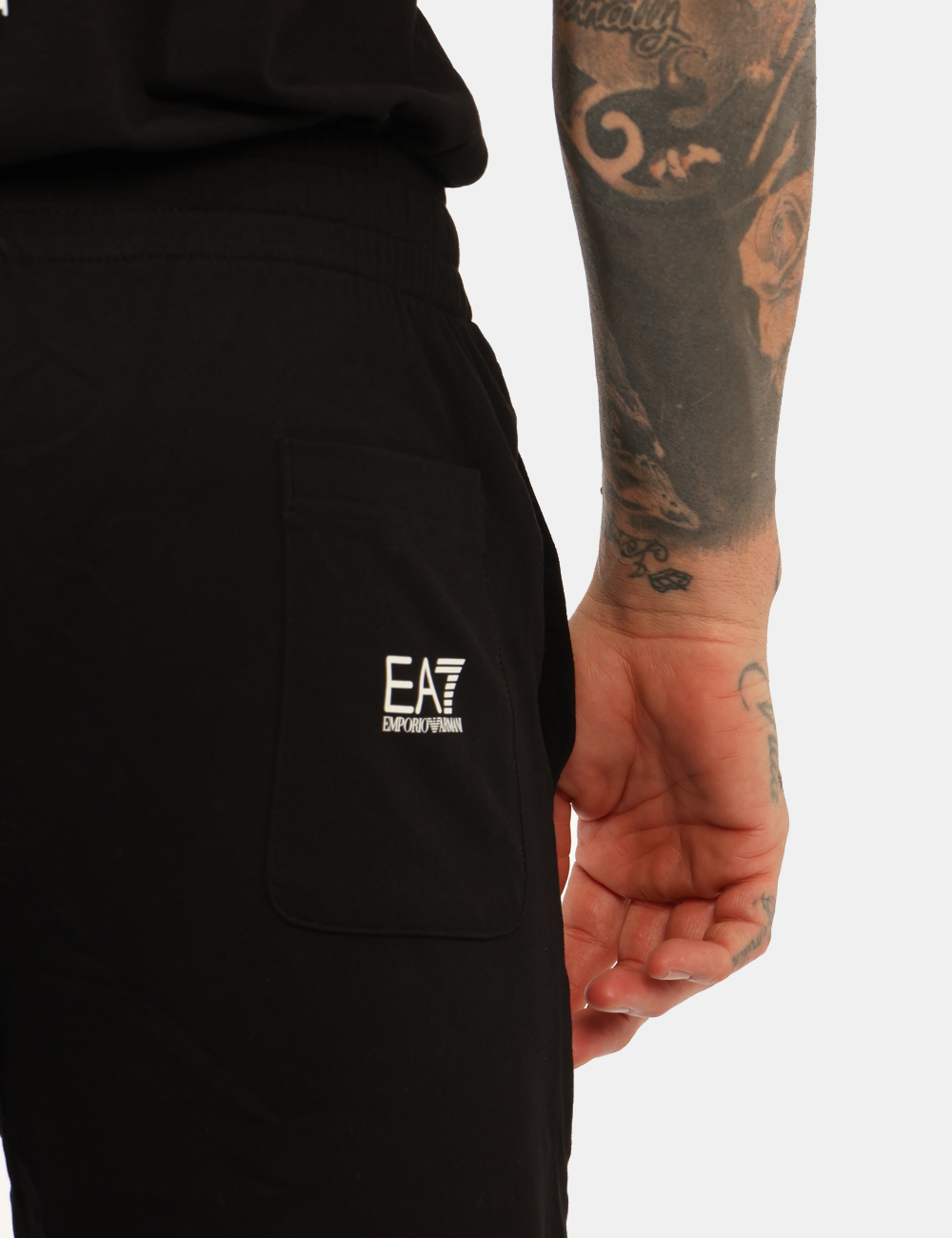 7M000571-AF13512-OA_BLACK-WHITE_AI25_5 Pantaloni EA7 Nero - Pantaloni in total nero, con stampa logo brand bianca, tasche a taglio trasversale sul fronte e tasca a
